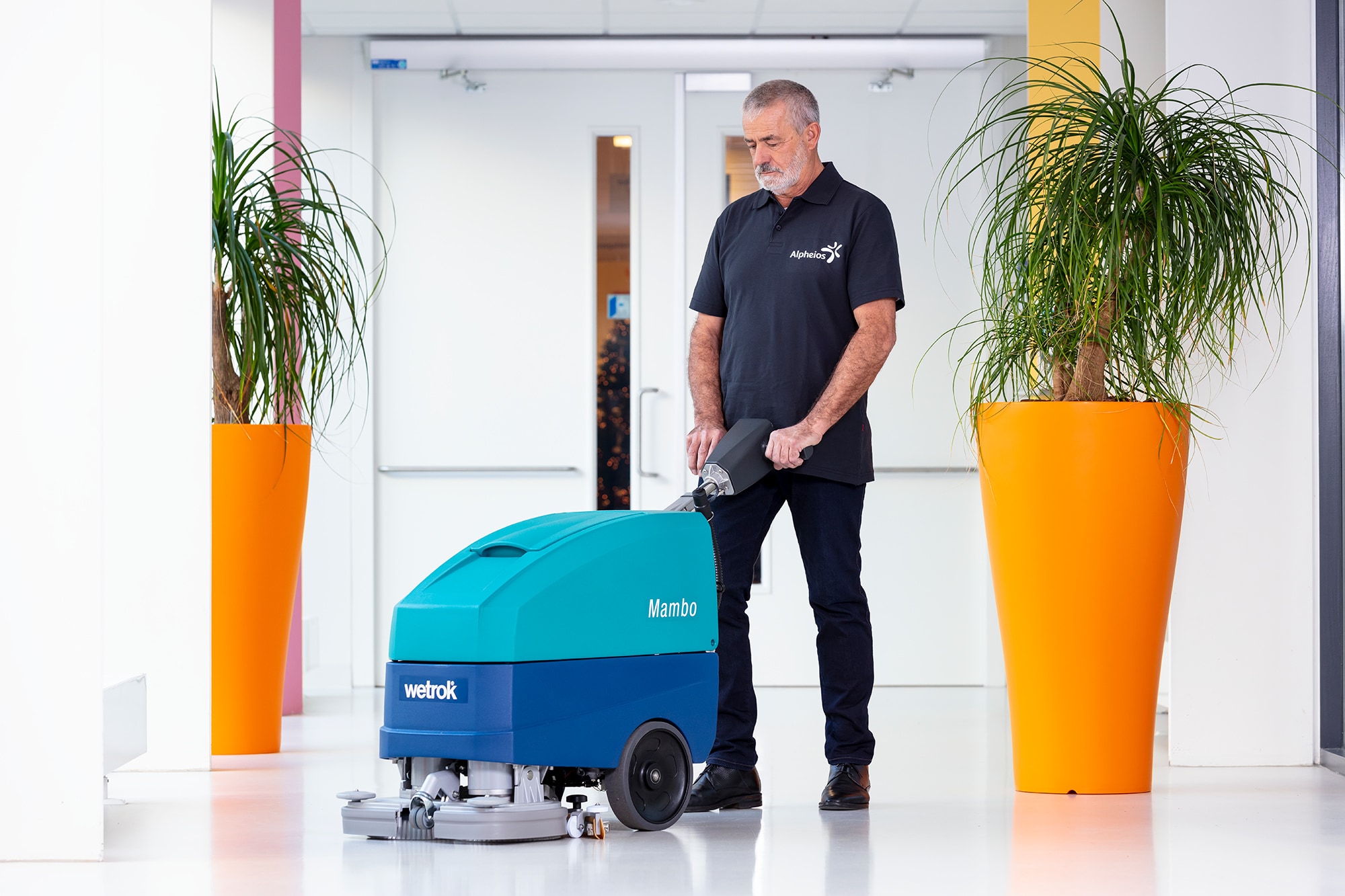 Schoonmaker die met een Wetrok Mambo de vloer schoonmaakt