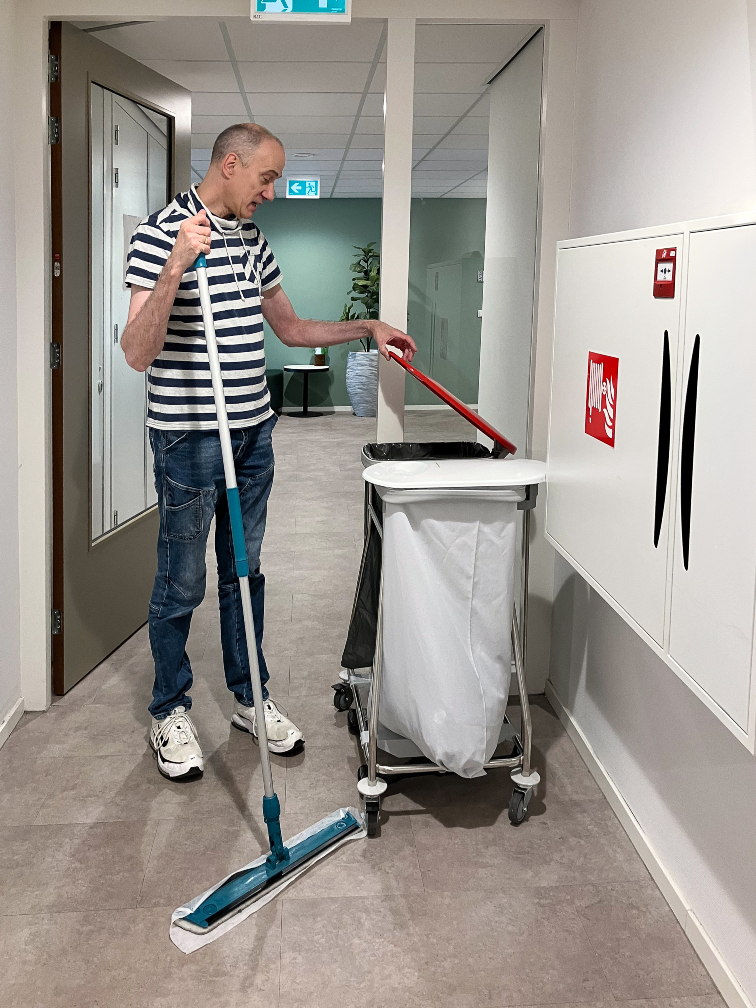 medewerker-amarant-met-stofwisser-bij-vuilnistrolley