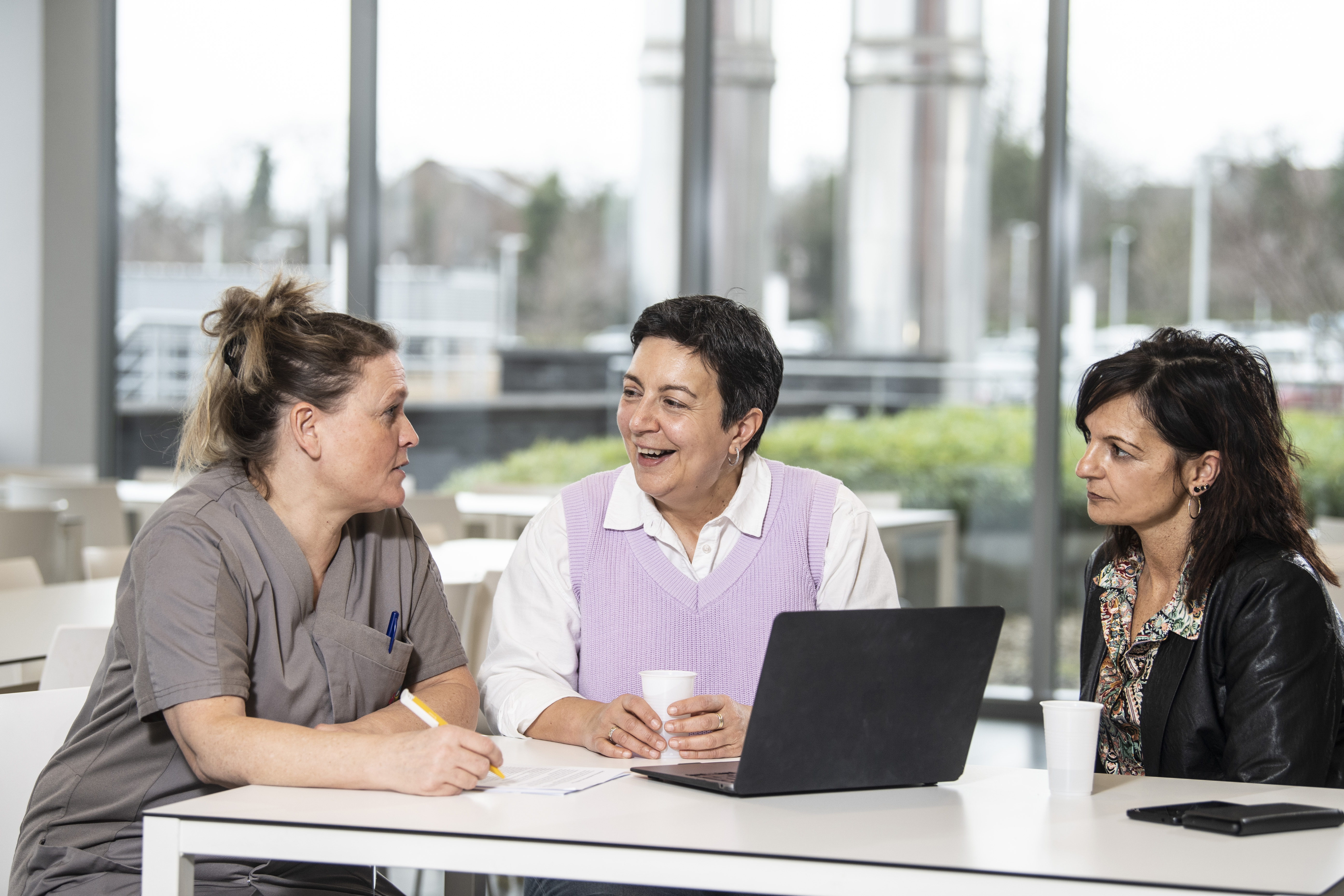 drie vrouwen zittend in overleg met laptop