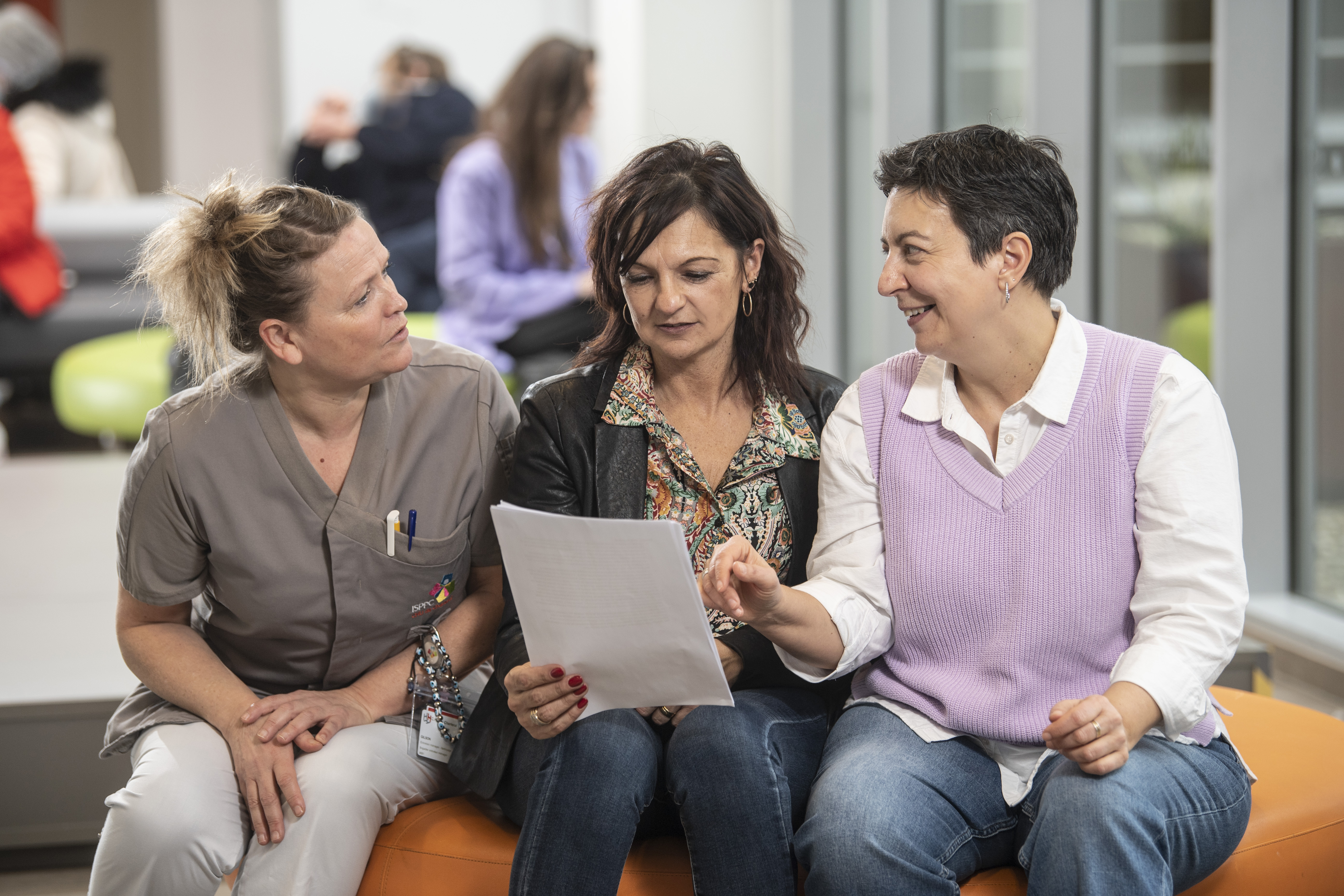 drie vrouwen zittend in overleg met papieren